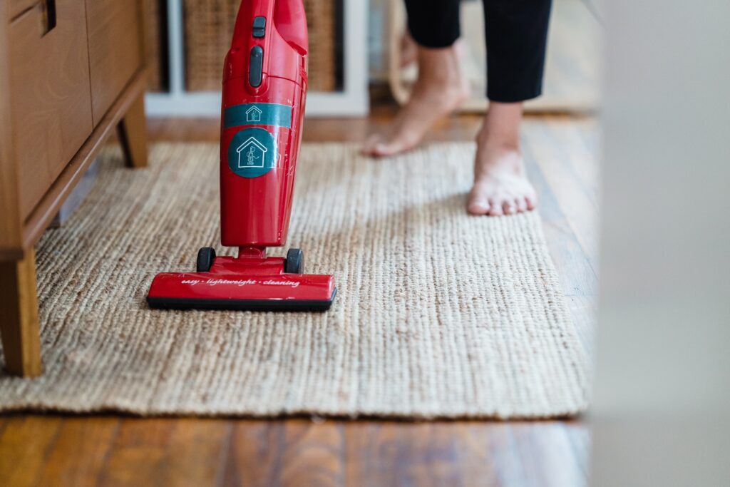 Woman vacuuming a tan area rug