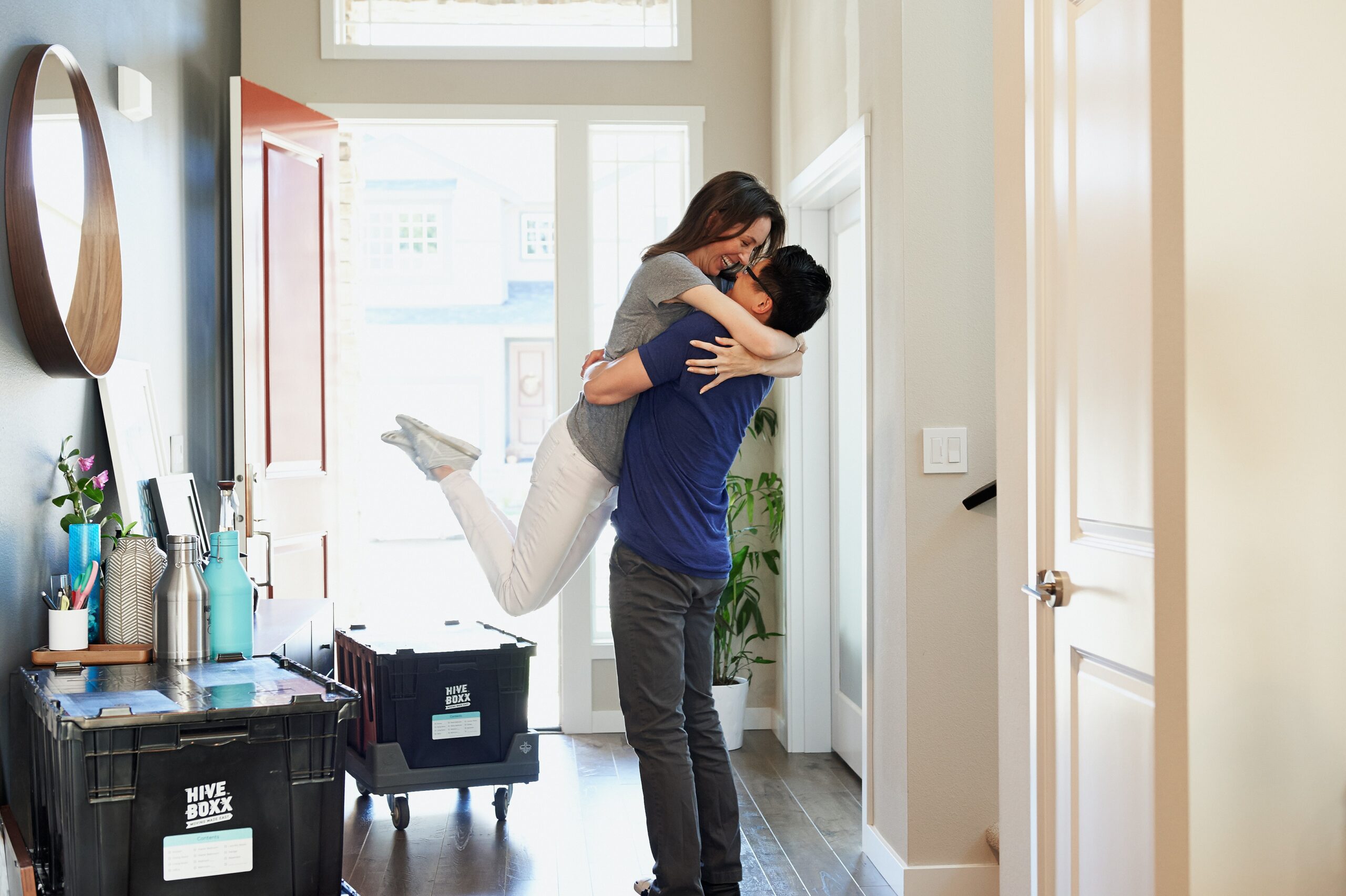 Man and woman hugging in the entryway of their house